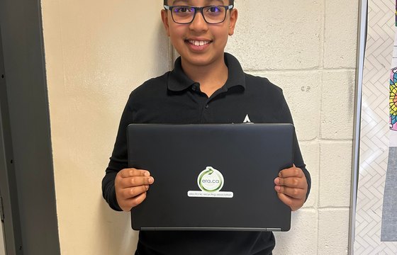 A student working on a refurbished laptop at home